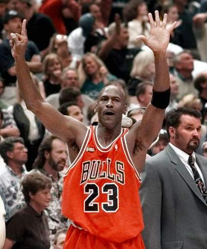 Michael Jordan puts up the six fingers after beating the Utah Jazz in the 1998 Finals. Jordan's Bulls had two separate three-peat runs in the 90's.